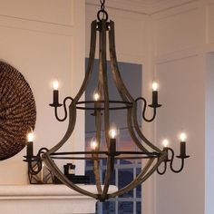 a chandelier hanging from the ceiling in a living room with candles lit up