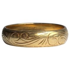 The 18carat gold band has fine scroll engraving and either side of the band there is a fine line framing the engraving. Ring Size: P 1/2 or 7 3/4 Band Width: 5mm Weight: 4.5g Art Deco Men’s Wedding Ring, Antique Engraved Round Band Ring For Formal Occasion, Heirloom Gold Engraved Ring For Formal Occasions, Luxury Etched Engraved Ring For Anniversary, Heirloom Yellow Gold Hallmarked Bands, Luxury Engraved Etched Ring For Anniversary, Heirloom Hallmarked Yellow Gold Bands, Classic Gold Engraved Ring For Ceremonial Use, Vintage Yellow Gold Engraved Ring With Intricate Design