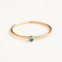 Our December Birthstone Ring features a gorgeous blue topaz-colored cubic zirconia. This dainty ring will be sure to add some sparkle to your everyday look. It makes the perfect gift for anyone with a December birthday, or anyone you'd like to remind that they are loved. Create your very own unique ring stack by stacking the birthstone rings of your loved ones! DETAILS 14k gold filled ring 1mm band with 2mm topaz-colored cubic zirconia Available in sizes 5-10 Matching jewelry: December Birthston December Birthstone Ring, Love Knot Ring, Birthstone Rings, Dot Ring, December Birthday, Topaz Color, Ring Stack, Gold Filled Ring, Bohemian Rings