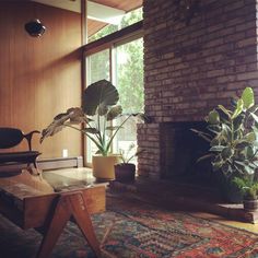 a living room filled with furniture and a fire place in front of a brick wall