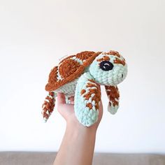 a hand holding a small crocheted star wars stuffed animal in it's palm