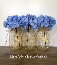 three mason jars with blue flowers in them