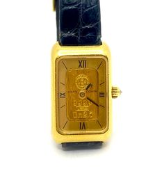 Mint Lady's Corum Swiss Quartz Wrist Watch with 24K gold ingot and 18K yellow gold. Watch #'d 886 circa 2010 with original Corum 11mm wide black lizard strap with gold  plated Corum Buckle.  Analog display with black roman numeral and hash mark dial,  sapphire crystal and sapphire crown.   Watch measures 1 1/16" long x 5/8" wide x 3/16" high including crystal.   Back case screws off. 2.5 grams.   Item Number: W3119 Luxury Yellow Gold Collectible Watch, Collectible Gold Watch With Rectangular Dial, Engraved Yellow Gold Watch With Rectangular Dial, Gold Watches With Diamond Hour Markers For Collectors, Gold Rectangular Engraved Watches, Gold Ingot, Diamond Cluster Earrings, Women Wrist Watch, Roman Numerals