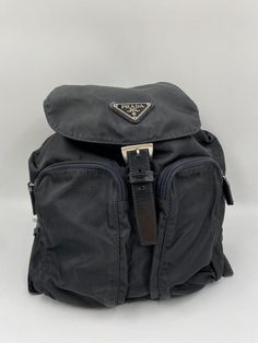 This vintage cult backpack from Prada is the ultimate throwback bag. When Prada released its original nylon backpack in 1984 it was an instant hit. This nylon backpack with a modern, minimalist design is decorated with the Prada enamel triangle logo. Underneath the flap with a leather strap and buckle, is a drawstring closure. There are two adjustable webbing shoulder straps with leather details and Prada branded buckles. There are two zipped pockets on the front. Inside features the iconic Prada logo lining and an interior zipped pocket for valuables. Lightweight, super cool yet durable and easy to wipe down! The backpack is in very good overall condition with some minor signs of wear. Please view all photos before buying to see the wear. Modern Minimalist Design, Prada Nylon, Logo Line, Handbag Wallet, Triangle Logo, Wallet Accessories, Diaper Backpack, Casual Backpack, Prada Bag