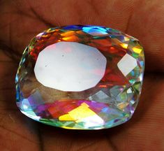 a close up of a person's hand holding a large crystal stone in their left hand