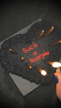 someone is holding a cake with candles in the shape of a heart that says such as scorpion