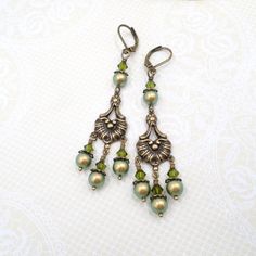 These new earrings were handmade by me with top quality elements.  I started with antiqued brass Victorian style chandelier links.  these are so sweet and pretty and full of ornate details.  They are stamped metal components that are hollow on the back.  To these I wired top quality crystals and pearls from a well known crystal maker, in shades of shimmery Iridescent Green and Olive Green.  I love the mossy greens against the warm metal.  The earrings hang a total of 3 inches including the antiq Antique Brass Chandelier Earrings As Gift, Vintage Style Metal Chandelier Earrings, Antique Brass Chandelier Earrings For Gift, Vintage Brass Chandelier Earrings For Wedding, Handmade Vintage Chandelier Earrings For Wedding, Antique Finish Bronze Wedding Earrings, Elegant Handmade Bronze Chandelier Earrings, Victorian Green Earrings For Gift, Handmade Victorian Chandelier Drop Earrings