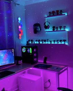 a computer desk with two monitors and speakers on it in a room that has purple lighting