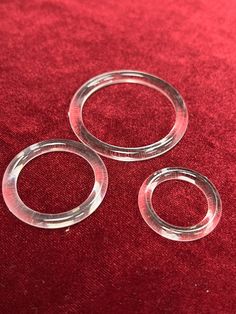 three clear rings sitting on top of a red cloth