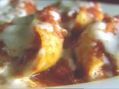 a close up view of some food on a plate with sauce and cheese over it