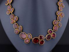 Immerse yourself in the romantic world of high fashion with this garnet riviere necklace. This Georgian piece was designed to please any lady of noble breeding, capturing her heart's desires with every glance. The extraordinary antique necklace (circa 1820) features 54 oval flat-cut garnets, foil and closed backed in 14k bloomed gold. The necklace measures 16 inches and it is in good condition with one surface reaching inclusion that is visible to the naked eye and some past, but well done, repa Victorian Ruby Necklace For Formal Occasions, Victorian Oval Jewelry For Opera, Antique Ruby Necklace For Formal Occasions, Vintage Ruby Necklace For Formal Occasions, Elegant Yellow Gold Garnet Necklace, Luxury Oval Jewelry For Opera, Elegant Oval Garnet Necklace, Evening Oval Rose Cut Diamond Jewelry, Oval Rose Cut Diamond Evening Jewelry