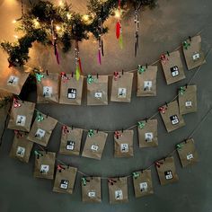 brown paper bags hanging from a string with christmas decorations on it and small presents tied to them