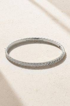 David Yurman updates its signature 'Cable' design, carving the wavy motif into this 18-karat white gold bangle to create the illusion of a chain. Alternate ridges are enhanced by light-reflecting diamonds that highlight the sculpted shape. It's such an easy collection to mix and match - every combination looks effortlessly elegant. Luxury Flexible Silver Bangle, Luxury White Gold Diamond Cut Bangle, Designer White Gold Bangle With Jubilee Bracelet, Luxury White Diamond Cut Bangle, Timeless White Gold Bangle With Diamond Cut, Luxury Sterling Silver Diamond-cut Bangle Bracelet, Luxury Diamond Cut Sterling Silver Bangle Bracelet, Luxury Sterling Silver Diamond Cut Bangle, White Gold Diamond-cut Bangle In Fine Jewelry Style