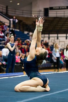 a woman in a blue leotard doing a handstand