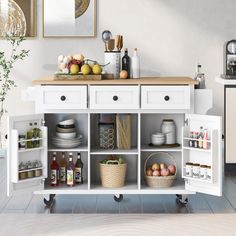 a kitchen with white cabinets and shelves filled with food