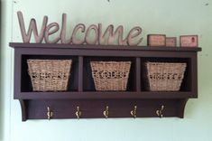 a wooden shelf with baskets on it and the words welcome above it that says,'welcome '