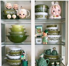 the shelves are filled with green and white dishes, figurines, and other decorative items