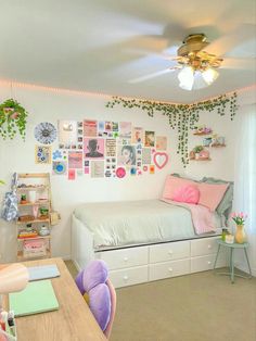 a room with a bed, desk and shelves filled with pictures on the wall above it