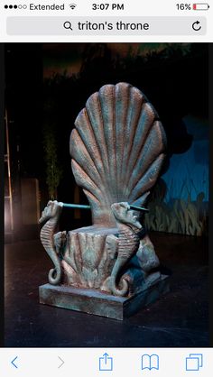 an image of a statue that looks like a shell with a dolphin on it's back