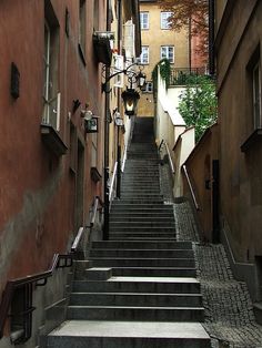 an alleyway with stairs leading up to buildings