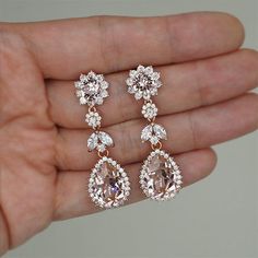 a person holding two pairs of earrings in their hand