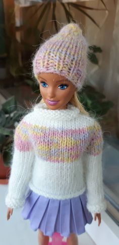 a doll is wearing a sweater and skirt