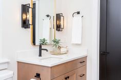 a bathroom with a sink, mirror and toilet paper dispenser in it