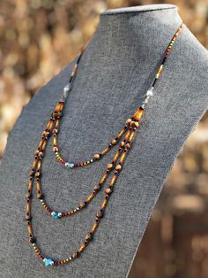 "Authentic Native American, handmade, tiered Cedar Juniper Berry seed with turquoise necklace. Cedar beads, colorful glass seed beads (size 11/0), round silver beads (6mm) and a gemstone bead are strung with jewelry wire and closed with lobster claw clasp. Jumpers are soldered closed. Navajo legend says Cedar beads, also known as \"Ghost Beads,\" will keep evil spirits and bad dreams away. For example, it is customary for Navajo mothers to place strung cedar beads on/near their traditional cradl Artisan Multi-strand Jewelry With Tiny Beads, Southwestern Brown Hand-strung Jewelry, Southwestern Brown Beaded Jewelry, Brown Beaded Southwestern Jewelry, Southwestern Style Brown Beaded Jewelry, Southwestern Style Brown Jewelry With Colorful Beads, Southwestern Brown Jewelry With Colorful Beads, Bohemian Multi-strand Spacer Beads Jewelry, Brown Heishi Beads Jewelry With Tiny Beads