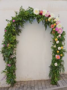 an arch made out of flowers and greenery