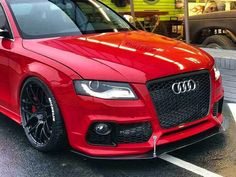 a red car is parked in the parking lot