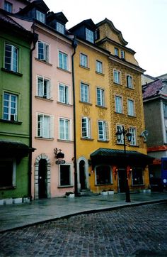 several buildings line the street in front of each other on a cobblestone road