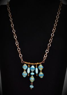 This necklace features beautiful Sky/Azure Blue etched picasso Czech glass beads with wonderful colors and detail.  Check out the 2nd picture which provides the best shot of the true colors on this handcrafted piece.  Bronze, light blue Cat's Eye beads, and baby blue czech rondelles are added and spaced across a bronze bar. The pendant is strung on medium sized cable style bronze chain.  The back features a hand made hammered hook which allows for length adjustability with the chain.  Back dangle finished this one-of-a-kind creation. Blue Beaded Chain Turquoise Necklace As Gift, Blue Turquoise Necklace With Beaded Chain As Gift, Turquoise Necklace With Dangling Beads For Gift, Light Blue Beaded Chain Jewelry Gift, Adjustable Dangle Glass Necklace, Artistic Blue Beaded Necklace, Adjustable Czech Glass Necklaces With Dangling Beads, Adjustable Czech Glass Necklace With Dangling Beads, Unique Blue Jewelry With Adjustable Chain