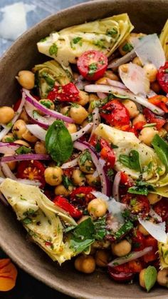 a bowl filled with salad and garnishes on top of a blue table