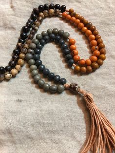 "This listing is for an acai seed bead mala necklace, 108 recycled and naturally dyed acai beads from Brazil and an oval guru salwag bead/palm bead from the Philippines.  The mala pictured is strung on organic hemp (peach/orange) with a handmade hemp tassel and knotted in 6 sections in 6 different colors (light grey, dark grey, tangerine, Sienna brown, dark natural, cream natural) each of an 18 count. 108 is a traditional spiritual number used in malas as a perfect derivative of 3, the number of Adjustable Brown Mala For Healing, Spiritual Brown Mala For Healing, Artisan 108 Beads For Meditation, Holistic Hand Knotted Round Bead Jewelry, Brown Bohemian Mala With 108 Beads, Brown Spiritual Beads For Meditation, Bohemian Brown Mala With 108 Beads, Brown Spiritual Mala For Meditation, Spiritual Brown Mala For Meditation