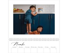 a calendar with an image of two children in the kitchen and one boy on the counter