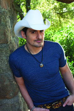 a man wearing a white cowboy hat and blue shirt is looking at the camera with an mp3 player in front of him