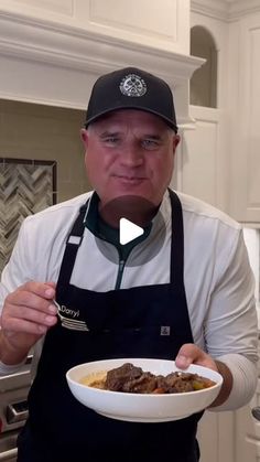 a man in an apron holding a bowl of food