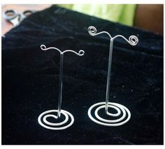 there are two pairs of earrings sitting on a black velvet tablecloth with scissors in the background