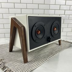 the speaker is made out of wood and has two speakers on it