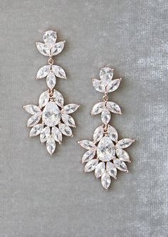 two pairs of earrings on a gray surface