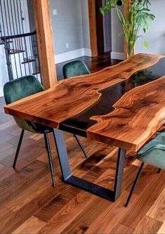 a dining table made out of wood and metal legs with green velvet chairs around it