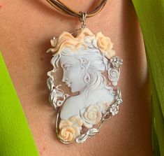 Crafted with meticulous care and artistry, the Hand-Carved Cameo Necklace for women embodies elegance and sophistication. This exquisite piece, skillfully handmade in Italy, showcases a delicate cameo of a nymph, exuding a timeless charm that captivates effortlessly. Whether as a thoughtful wedding gift or a gesture of appreciation for a special woman, this necklace is a symbol of refined taste and creativity. The intricate detailing and the superior craftsmanship make it a standout accessory th Elegant Cameo Jewelry, Elegant Cameo Necklaces For Wedding, Elegant Cameo Necklace For Formal Occasions, Elegant Cameo Necklace For Wedding, Elegant Carved Pendant Necklace, Elegant Carved Round Pendant Necklace, Exquisite Oval Necklace With Large Pendant, Luxury Cameo Pendant Jewelry, Intaglio Pendant Necklace For Wedding