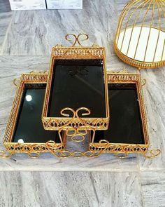 two mirrors sitting on top of a table next to a birdcage and mirror