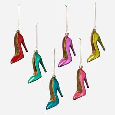 four pairs of colorful high heel shoes hanging from strings on a white background with clippings