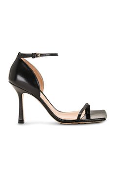 Find BOTTEGA VENETA Stretch Sandal on Editorialist. Bottega Veneta Stretch Sandal in Black Lambskin leather upper with rubber-injected leather sole. Made in Italy. Ankle strap with buckle closure. Toe loop. Lambskin leather lining. Square toe with block heel. Approx 95mm/ 3.75 inch heel. BOTT-WZ409. 729742-VBSF0-1000. About the designer: Bottega Veneta – inspiring individuality with innovative craftmanship since 1966. Creativity lies at the heart of all that we do. Born in Vicenza the house is rooted in Italian culture yet maintains a truly global outlook. An inclusive brand with exclusive products Bottega Veneta is as much of a feeling as it is an aesthetic. Evening Calf Leather Heels With Buckle Closure, Evening Heels With Buckle Closure In Calf Leather, Sleek Calf Leather Sandals With Padded Heel, Modern Calf Leather Heels With Single Toe Strap, Sleek Calf Leather Heels With Single Toe Strap, Calf Leather Sandals With Padded Heel And Ankle Strap, Calf Leather Sandals With Ankle Strap And Padded Heel, Ankle Strap Sandals With Padded Heel In Calf Leather, Designer Heels With Ankle Strap And Buckle Closure