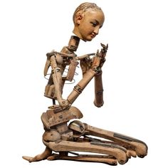 a wooden sculpture of a woman holding something in her hands