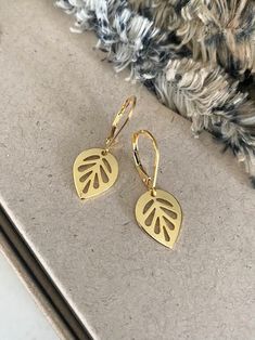 "These 24k gold plated leaf dangle earrings exude elegance with their delicate design, making them perfect for everyday wear. The earrings are finished with gold filled lever backs for a secure wear.  Their subtle shimmer adds a touch of sophistication to any outfit, effortlessly elevating your style. Crafted with attention to detail, they offer a timeless appeal that seamlessly transitions from day to night, ensuring you feel refined and chic at all times.  Also available in rhodium plated finished with sterling silver lever backs. The earrings measure just over 1\" from end to end.  The leaf charms are approx 14x11mm. You may also like to check out more of my earrings here: http://etsy.me/2e2BGZl Free first class USPS domestic USA shipping" Yellow Gold Leaf-shaped Earrings For Pierced Ears, Yellow Gold Leaf Earrings, Gold Leaf-shaped Nickel-free Earrings, Everyday Gold Leaf-shaped Jewelry, Everyday Gold Leaf Jewelry, Gold Delicate Hypoallergenic Teardrop Earrings, Gold-plated Leaf-shaped Earrings, Gold Leaf-shaped Single Earring, Gold Single Leaf-shaped Earring