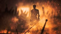 a man standing in the middle of a fire filled field