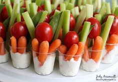 carrots, celery and tomatoes are arranged in small cups