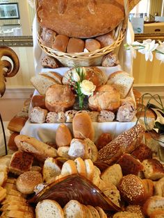 a table topped with lots of different types of breads and buns next to each other